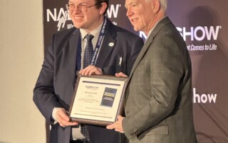 Liam Power (left), systems engineer, ONE Media, receiving the 2023 NAB Best Paper Award from Lynn Claudy, senior vice president, Technology, NAB.